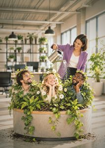 Mitarbeiterbindung: Frau gießt Mitarbeiter, die aussehen wie Blumen